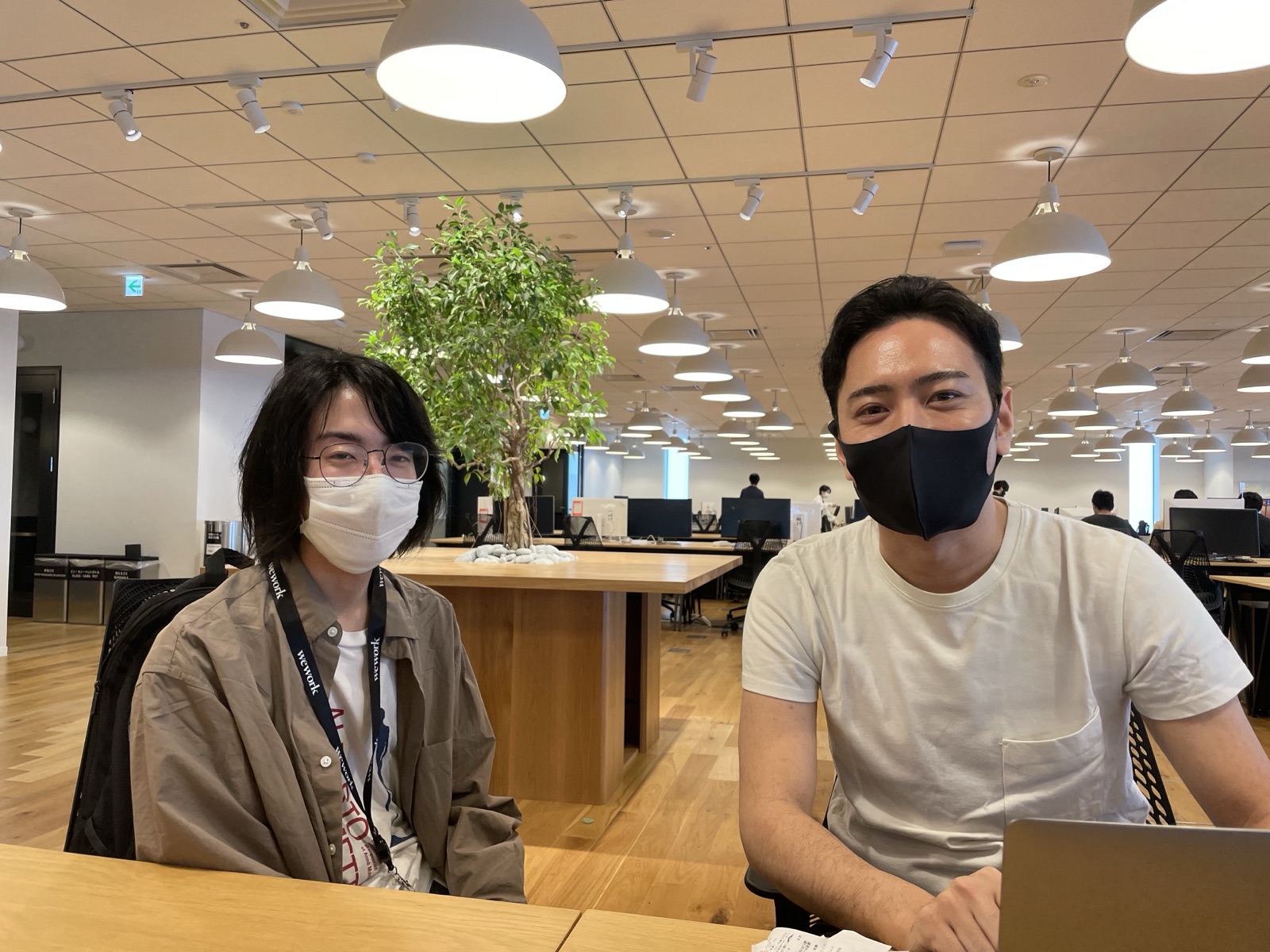 コワーキングスペースで並んで作業する創業者2人